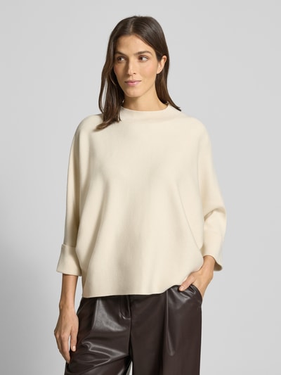 Frauenmodel trägt Strickpullover aus Viskose-Mix mit 3/4-Arm von Comma, Relaxed-Fit, Rundhalsausschnitt, Aufschlag an Ärmeln, cremefarben, glatte Textur, Damenmode, Ganzkörperansicht von vorne.
