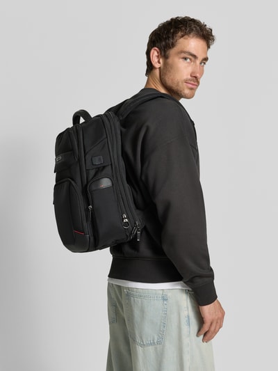 Männermodel trägt Rucksack aus Kalbsleder-Mix mit Logo-Detail Modell 'Pro-DLX' von Samsonite in Schwarz, Strukturmuster, Ganzkörperansicht Rückansicht. Hauptfach mit Reißverschluss, verstellbare Schulterriemen, Maße 34x44x16 cm, Länge Schulterriemen 58 cm.