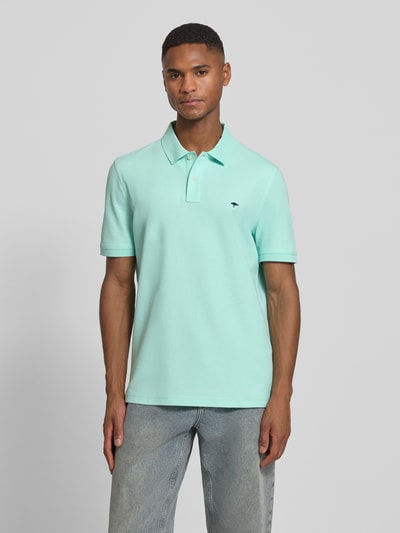 Männermodel trägt Regular Fit Poloshirt mit Logo-Stitching von Fynch-Hatton in Mintgrün, reine Baumwolle, Polokragen, Ganzkörperansicht von vorne.