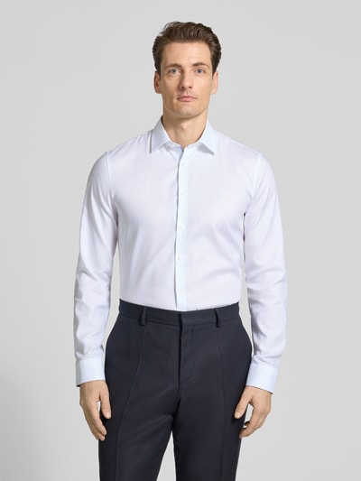 Männermodel trägt Super Slim Fit Business-Hemd mit Kentkragen von OLYMP No. Six aus Baumwoll-Elasthan-Mix, weiß, Ganzkörperansicht von vorne.