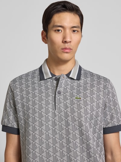 Männermodel trägt Regular Fit Poloshirt mit Baumwoll-Anteil von Lacoste, Optik: Unifarben, Allover-Muster, Nahaufnahme Oberkörper.