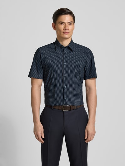 Männermodel trägt Regular Fit Businesshemd mit kurzem Arm Modell 'P-LIAM' von BOSS, dunkelblau mit Allover-Muster, Ganzkörperansicht von vorne.