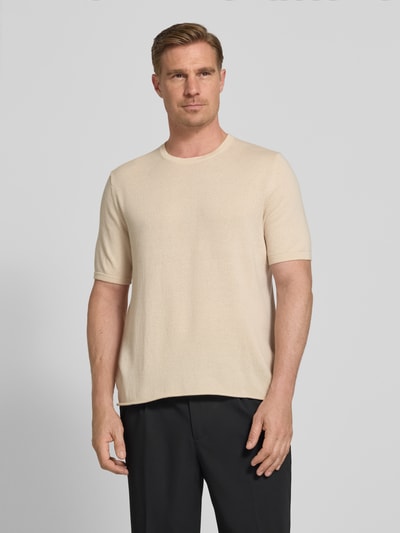 Männermodel trägt Strickshirt mit Kaschmir-Anteil und Knopfleiste von FTC-Cashmere in Beige, Baumwoll-Mix, Slim-Fit, Polokragen, Ganzkörperansicht von vorne.