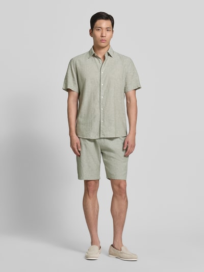 Männermodel trägt Regular Fit Freizeithemd aus Leinen-Baumwoll-Mix von MCNEAL in hellem Grün, Knopfleiste, Kentkragen, Ganzkörperansicht von vorne, Rückenlänge bei Größe M 74 cm, Schulterbreite bei Größe M 50 cm, Ärmellänge bei Größe M 25 cm.