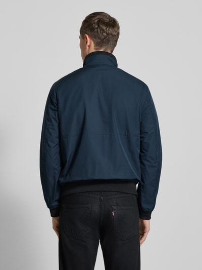 Männermodel trägt dunkelblaue Regular Fit Jacke mit Stehkragen von MCNEAL, elastische Abschlüsse, Rückansicht, Ganzkörperansicht.