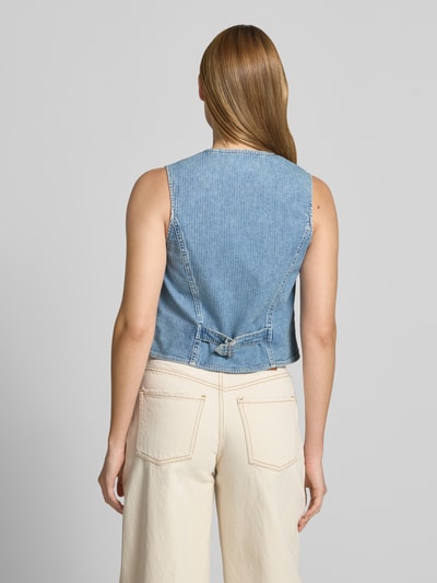 Frauenmodel trägt Regular Fit Weste in Denim-Optik von Mustang aus Baumwoll-Mix mit Paspeltaschen, Rückansicht Ganzkörperansicht.