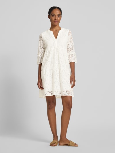 Frauenmodel trägt Loose Fit Spitzenkleid aus Baumwoll-Mix Modell 'HONEY' von Vero Moda, Optik: Unifarben, Muster: Spitzen-Muster, 3/4-Arm, Glockenärmel, knielang, V-Ausschnitt, Materialverarbeitung: Spitze, Material: Baumwoll-Mix, Ganzkörperansicht von vorne.