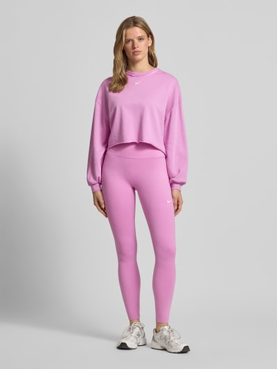 Frauenmodel trägt Leggings mit Logo-Print Modell 'One' von NIKE TRAINING in Pink, Material-Mix mit Stretch-Anteil, Slim-Fit, Elastischer Bund, Ganzkörperansicht von vorne.