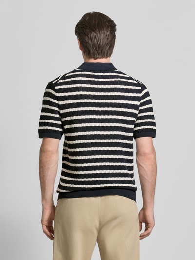 Männermodel trägt Poloshirt mit Polokragen und kurzer Knopfleiste von MCNEAL, Streifenmuster in Schwarz und Weiß, Regular Fit, Rückenansicht, reine Baumwolle.
