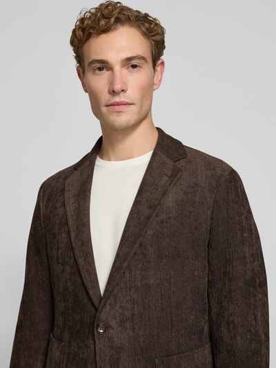Männermodel trägt Regular Fit Sakko mit Reverskragen Modell 'BENITO' von CINQUE, braune Textur, elastischer Material-Mix, Nahaufnahme Oberkörper. Kontext: Herren Sakko, aufgesetzte Taschen, Rückenlänge 74 cm, Schulterbreite 42 cm, Ärmellänge 65 cm.