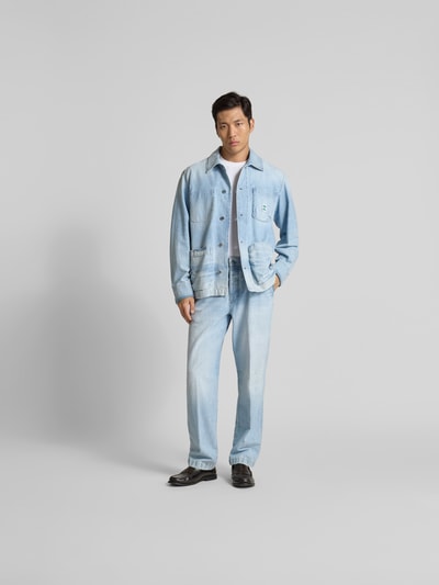 Männermodel trägt Relaxed Fit Hemdjacke in Denim-Optik von Closed, Reine Baumwolle, Aufgesetzte Taschen, durchgängige Knopfleiste, Rückenlänge 110 cm, hellblaue Farbtöne, glatte Textur, Ganzkörperansicht von vorne.