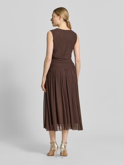 Frauenmodel trägt Midikleid aus Mesh in asymmetrischem Look von Christian Berg Woman Selection in Braun, fließender Stoff, Ganzkörperansicht Rückansicht.