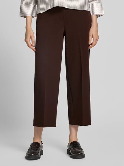 Vrouwenmodel draagt Regular Fit Culotte met viscose van s.Oliver RED LABEL in donkerbruin met rechte pijpen, detailopname onderlichaam.