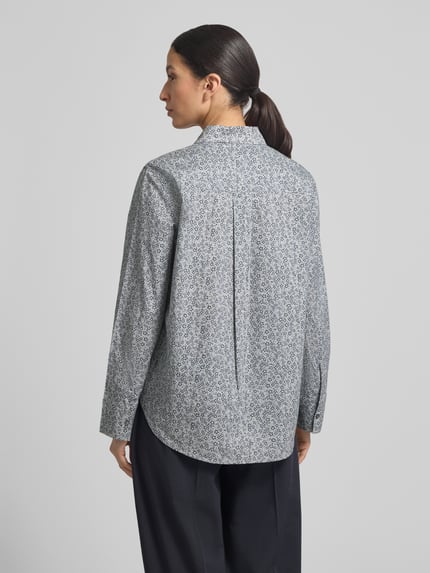 Männermodel trägt Regular Fit Hemdbluse aus reiner Baumwolle von Marc O'Polo, allover gemustert, krój regular fit, Hemdblusenkragen, Cacharel-Falte, Knopfleiste, lange Ärmel mit Manschette, leicht abgerundeter Rumpfabschluss, papertouch-popeline, Ganzkörperansicht Rückansicht.
