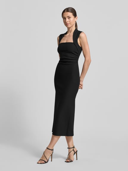 Frauenmodel trägt schwarzes Midikleid mit Karree-Ausschnitt, figurbetonter Schnitt, Modell 'Rose Bodycon' von Forever New, Ganzkörperansicht von vorne. Material-Mix mit Stretch-Anteil.
