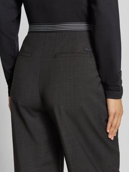 Vrouwenmodel draagt Weite Hose met Woll-Anteil van Lacoste in donkergrijs met fijne textuur, detailopname achterkant