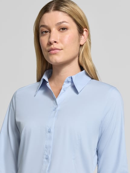 Frauenmodel trägt Regular Fit Langarmbluse aus Baumwoll-Mix von Tom Tailor in Hellblau, glatte Textur, Damen Langarmbluse, Nahaufnahme Oberkörper.