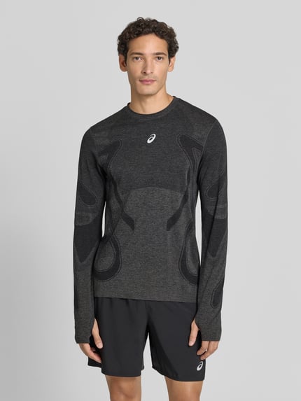 Männermodel trägt Longsleeve mit Logo-Print und Rundhalsausschnitt von ASICS, grau-schwarze Farbtöne, gerader Schnitt, Ganzkörperansicht von vorne
