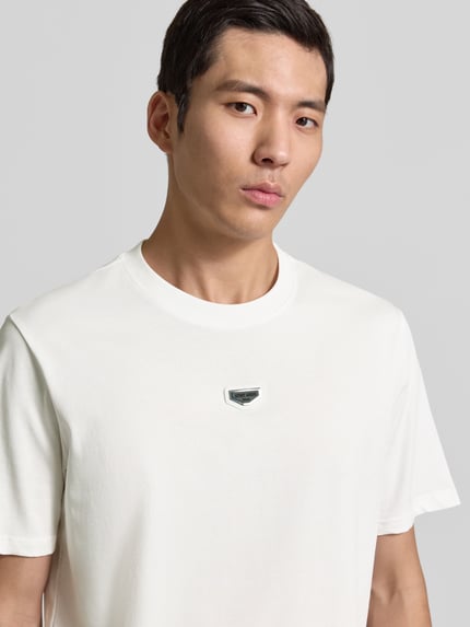 Männermodel trägt T-Shirt mit Label-Detail von Antony Morato in Weiß, reine Baumwolle, Regular Fit, Nahaufnahme Oberkörper.