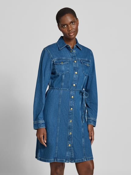 Frauenmodel trägt Jeanskleid mit Bindegürtel von GANT in Medium Wash Denim mit Zierknöpfen, Ganzkörperansicht von vorne.