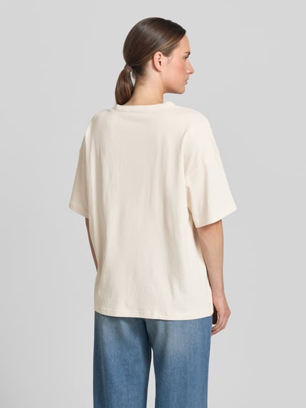 Frauenmodel trägt Relaxed Fit T-Shirt mit floralem Stitching von JAKE*S STUDIO WOMAN in Creme, Halbarm, Rundhalsausschnitt, Rückenlänge 64 cm, Ganzkörperansicht Rückansicht.