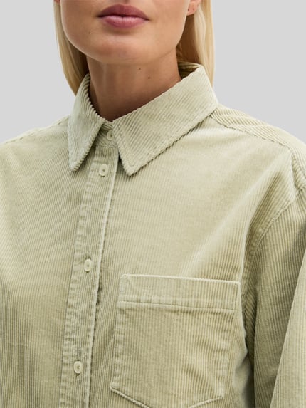 Frauenmodel trägt Regular Fit Langarmbluse aus Baumwoll-Mix von Marc O'Polo in hellem Beige mit feiner Cordstruktur, Nahaufnahme Oberkörper. Damen Langarmbluse von Marc O'Polo.