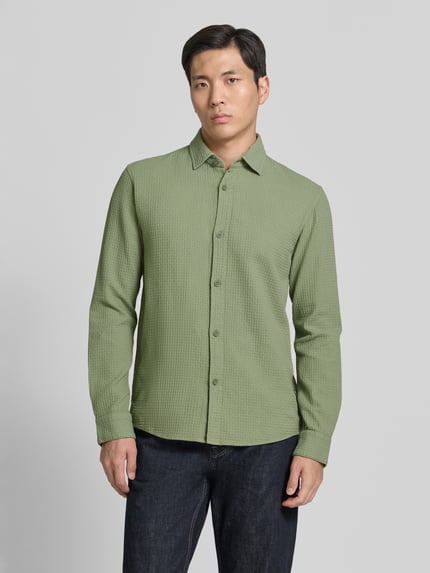 Männermodel trägt Relaxed Fit Freizeithemd aus reiner Baumwolle von Tom Tailor Denim, Optik: Unifarben, Ganzkörperansicht von vorne.