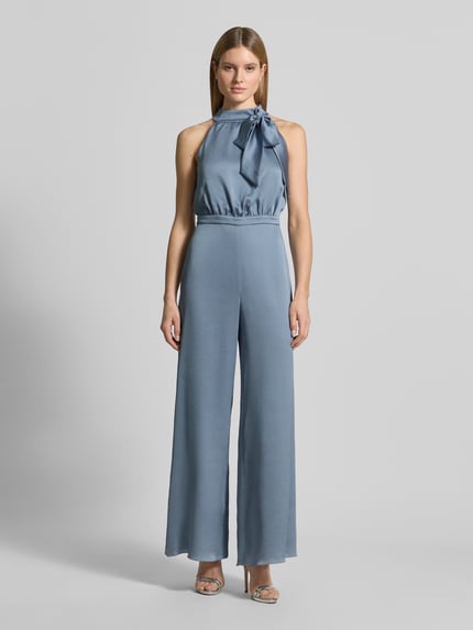 Vrouwenmodel draagt Regular Fit Jumpsuit met Zierschleife van Swing, structuurpatroon, opstaande kraag, mouwloos design, getailleerd, regular fit, ruglengte maat 36: 38 cm, borstwijdte maat 36: 45 cm, totale lengte maat 36: 150 cm, binnenbeenlengte maat 36: 83 cm. Ganzekörperaanzicht van voren.
