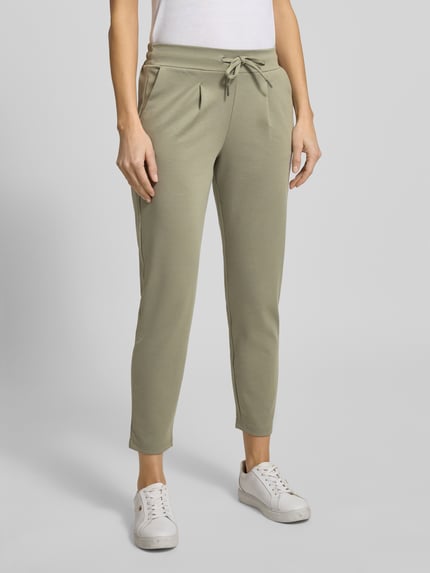 Frauenmodel trägt Slim Fit Stoffhose mit Viskose-Anteil Modell 'Rizet' von B.Young in hellem Grün, elastischer Bund, Ganzkörperansicht von vorne.