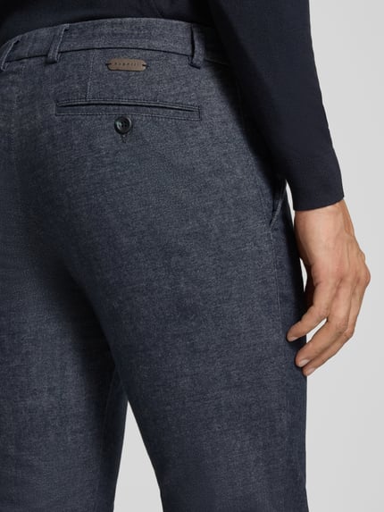 Männermodel trägt Modern Fit Hose mit Eingrifftaschen von bugatti, Baumwoll-Mix mit Viskose-Anteil, fein strukturiert, Nahaufnahme Rückansicht.