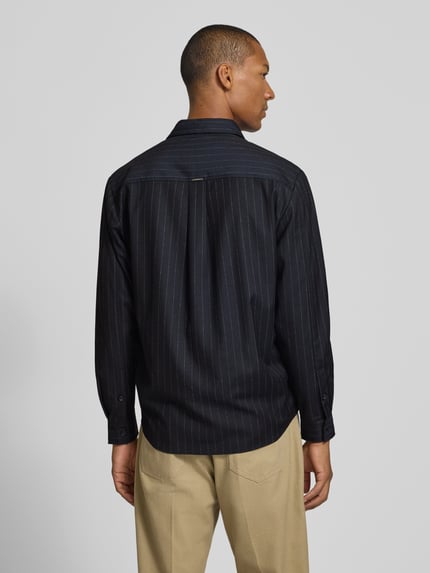 Męski model nosi Regular Fit Overshirt mit Pattentaschen od Antony Morato, Mieszanka materiałów z dodatkiem wiskozy, krój regular fit, kołnierzyk typu kent, listwa guzikowa, kieszenie z patką, zaokrąglony dół, sportowe mankiety, długość tyłu w rozmiarze 46: 75 cm, ciemne tkaniny z delikatnym prążkiem, widok całej sylwetki z tyłu.