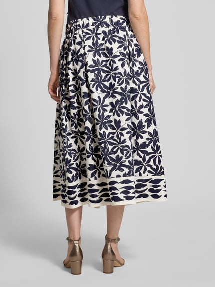 Frauenmodel trägt Faltenrock im Allover-Look mit elastischem Bund von ROBE LÉGÈRE aus Baumwoll-Elasthan-Mix, A-Linie, Midirock, Ganzkörperansicht Rückansicht
