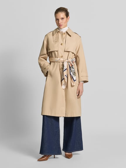 Vrouwenmodel draagt Trenchcoat met Bindegürtel van Liu Jo White, beige katoenmix, regular fit, platte kraag, knoopsluiting, strikceintuur, ruglengte maat S 112 cm, schouderbreedte 48 cm, borstwijdte 56 cm, mouwlengte 58 cm, volledige lichaamsaanzicht vooraan.