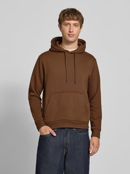 Männermodel trägt hoodie met kangoeroezak Model 'BRADLEY' van JACK & JONES in bruin, materiaalmix met katoen, los model, capuchon met tunnelkoord, ruglengte maat M 64 cm, mouwlengte maat M 70 cm, gladde textuur, Ganzkörperansicht van voren.