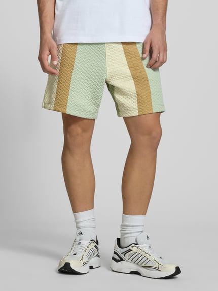Männermodel trägt Straight Fit Shorts mit Strukturmuster von BLKVIS im Elastischer-Material-Mix mit Rayon-Anteil, Ganzkörperansicht von vorne.