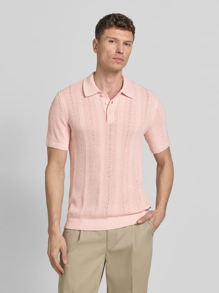 Męski model nosi Slim Fit Poloshirt mit Knopfleiste od Jack & Jones Premium w jasnoróżowym kolorze, bawełniany miks, krój slim fit, kołnierzyk polo, zapięcie na guziki, długość pleców w rozmiarze M: 72 cm, widok całej sylwetki z przodu.