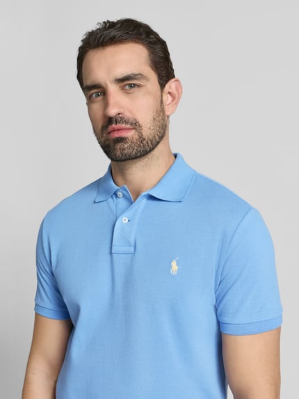 Männermodel trägt Poloshirt mit Label-Stitching von Polo Ralph Lauren in Blau, reine Baumwolle, Regular Fit, Nahaufnahme Oberkörper.