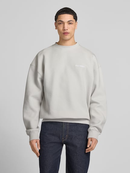 Männermodel trägt Oversized Fit Sweatshirt mit Logo-Stitching Modell 'Tate' von Pegador im Baumwoll-Mix, Strukturmuster, Rundhalsausschnitt, elastische Abschlüsse, Ganzkörperansicht von vorne.