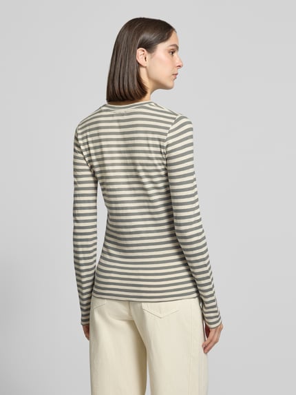 Frauenmodel trägt Langarmshirt mit feiner Rippstruktur von MARC O'POLO, mehrfarbig gestreift, Rundhals, Ganzkörperansicht Rückansicht.