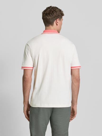 Männermodel draagt Regular Fit poloshirt uit zuiver katoen model 'BLOCKS' van BOSS Orange, look: effen, applicatie met labelstitching, polokraag, V-hals, 2-knoopsluiting, korte mouw, materiaalverwerking: piqué, kleur wit met roze accenten, zichtbare structuur. Ganzkörperansicht Rückansicht.