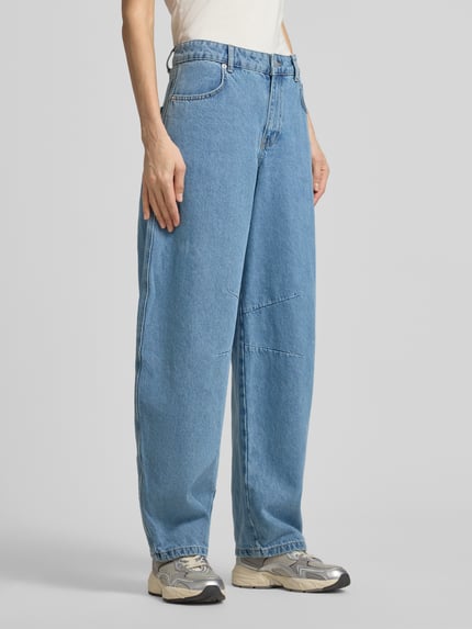 Frauenmodel trägt Barrel Fit Jeans mit Eingrifftaschen Modell 'Alannah' von Neo Noir aus reiner Baumwolle in mittlerem Blau, Ganzkörperansicht von vorne.