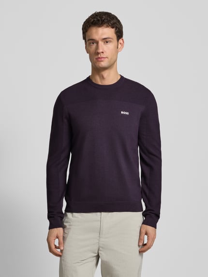 Męski model nosi Regular Fit Strickpullover mit Woll-Anteil Modell 'MOMENTUM' von BOSS Green, efekt: jednolity kolor, naszywka z logo, sweter z dzianiny, okrągły dekolt, prążkowane zakończenia, materiał: dzianina z dodatkiem wełny, Ganzkörperansicht von vorne.