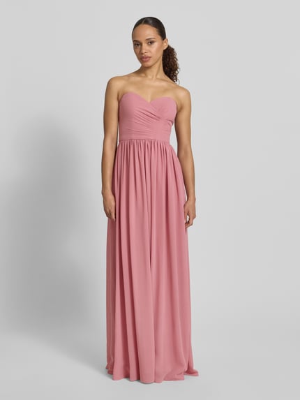 Frauenmodel trägt Maxikleid im Off-Shoulder-Look von Mascara in Altrosa, taillierter Schnitt aus Chiffon, Ganzkörperansicht von vorne.