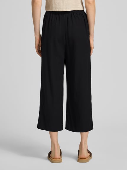 Vrouwenmodel draagt Regular Fit Culotte uit viscose-linnenmix model 'MYMILO' van Vero Moda, effen zwart, met zijzakken, flammé garen; volledige lichaamsaanzicht achteraan.