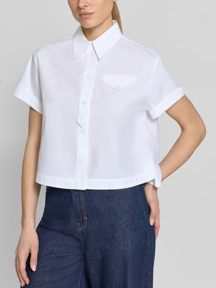 Vrouwenmodel draagt Boxy Fit Bluse mit Brusttasche van Luisa Cerano, wit katoen, borstzak, omgeslagen mouw, hemdkraag, knopenlijst, volledige voorkant, close-up bovenlichaam.