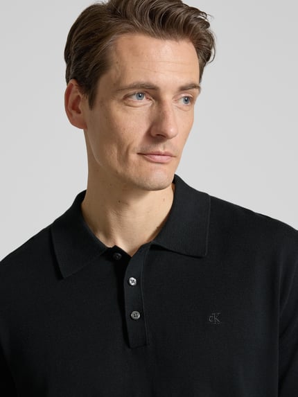 Männermodel trägt Regular Fit Poloshirt in Strick-Optik Modell 'Supima' von CK Calvin Klein aus reiner Baumwolle, Nahaufnahme Oberkörper