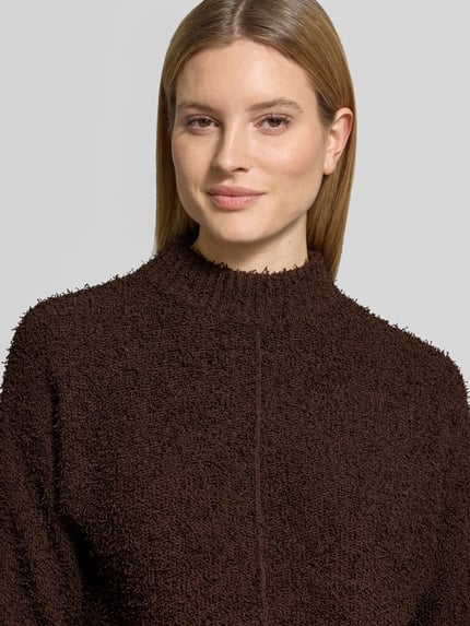 Modelka kobieca nosi sweter z mieszanki bawełny o prostym kroju, model 'Punew' od OPUS, prążkowane wykończenia, zbliżenie na górną część ciała.