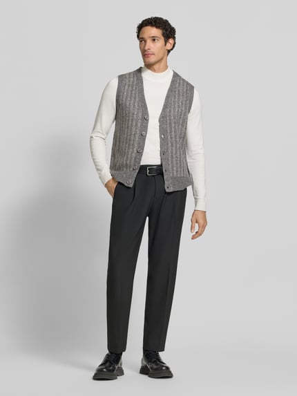 Männermodel trägt Strickweste mit V-Ausschnitt und Knopfleiste von Lindbergh, grau meliert, Regular Fit, Ganzkörperansicht von vorne. Material-Mix mit Baumwoll-Anteil, Rücklänge 64 cm, Schulterbreite 43 cm, Brustweite 50 cm.