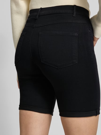 Vrouwenmodel draagt Slim Fit Jeansshorts met fixeerbare omslag model 'RAIN' van Only, denimlook, 5-pocket, viscosemix, detailopname rugaanzicht.