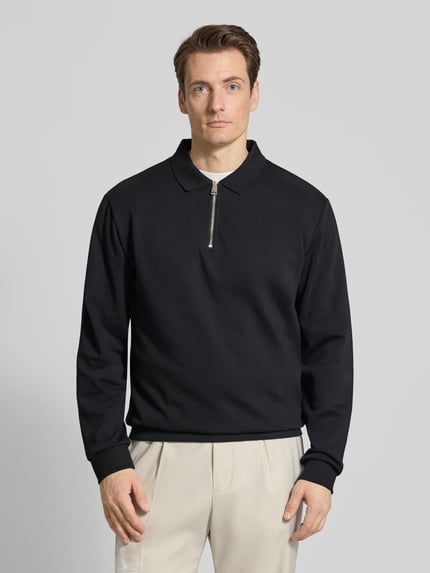 Männermodel trägt Sweatshirt mit Polokragen und Reißverschluss von Lindbergh aus Baumwoll-Mix im Regular-Fit, schwarze Farbe, Ganzkörperansicht von vorne. Rückenlänge bei Größe M: 70 cm.